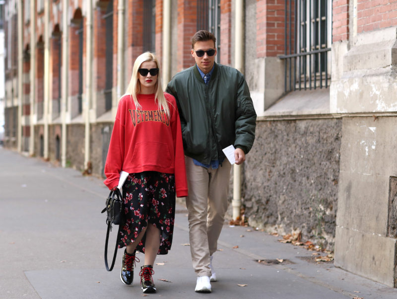 fashion couple, red oversize sweater, dress, boots, sunglasses, green jacket, pants, sneakers